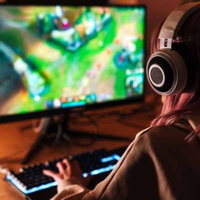 Young woman playing games on a personal computer. Image, Adobe.